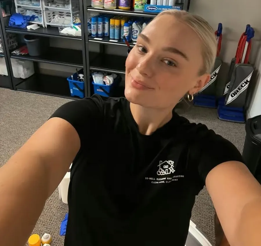 Maigan in front of the supply shelves at her cleaning company